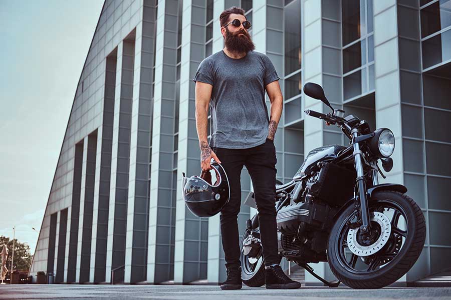 Motorcycle rider standing next to his bike